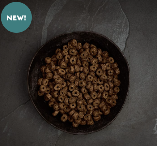 Metal bowl filled with Canagan Senior Light Small Breed Dog food on a dark table.