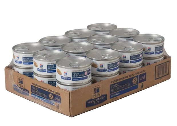 Cardboard box filled with cans of Hill's Science Diet pet food on a beige background
