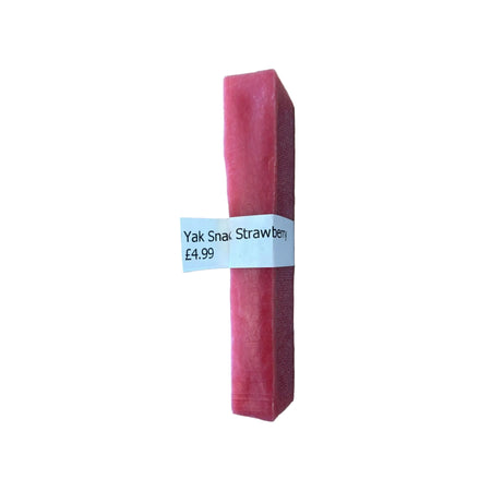 Strawberry-flavored Yak Snack on a wooden surface with a price label.